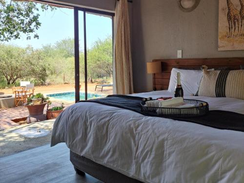 a bedroom with a bed with a view of a pool at La Dolce Vita in Hoedspruit