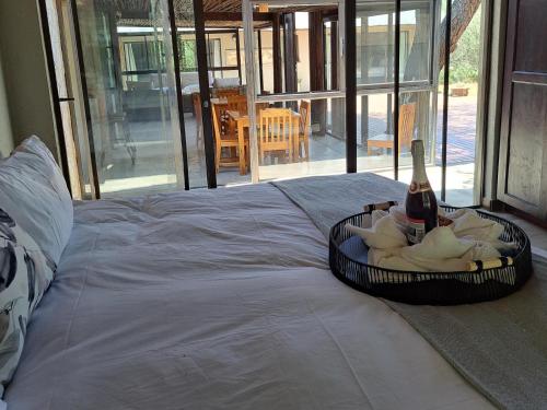 a basket with a bottle of wine on a bed at La Dolce Vita in Hoedspruit