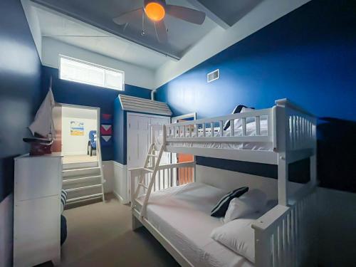 a bedroom with two bunk beds and a blue wall at Marlin at the Lake - Downtown Sandusky in Sandusky