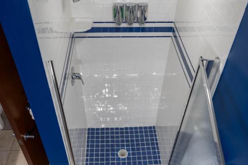 a bathroom with a shower with a blue tile floor at Marlin at the Lake - Downtown Sandusky in Sandusky