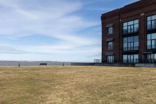 a building with a grass field in front of it at Marlin at the Lake - Downtown Sandusky in Sandusky