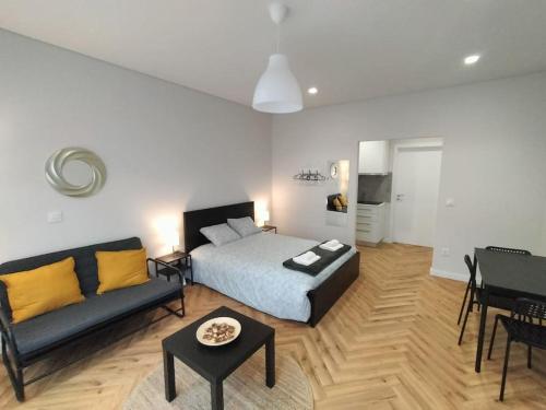 - une chambre avec un lit, un canapé et une table dans l'établissement Heart of the City Suites - B, à Vila Nova de Gaia