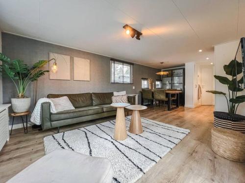 a living room with a couch and a table at Chalet op familiepark Veluws Hof op de Veluwe in Hoenderloo