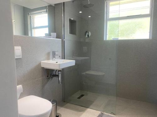 a bathroom with a toilet and a sink and a shower at Lock up & go apt w/ great views in Simons Town in Cape Town