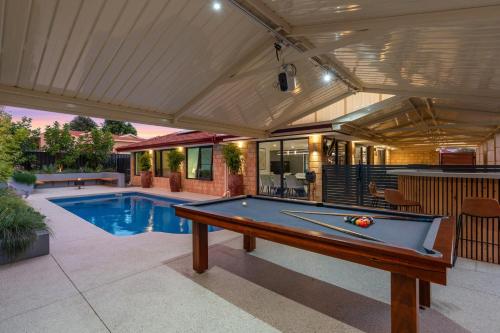 a pool table in a backyard with a pool at Luxury 5br villa with pool in Kinross