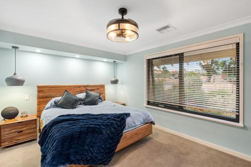 a bedroom with a bed and a large window at Luxury 5br villa with pool in Kinross