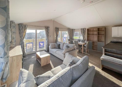 a large living room with couches and a piano at Shear Barn Holiday Park in Hastings