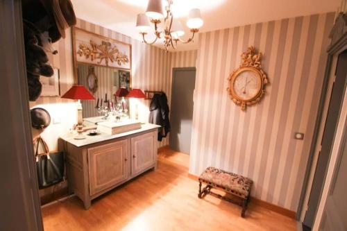une chambre avec une horloge sur le mur et une chaise dans l'établissement Le BILLANCOURT comfortable, spacious and well-equipped apartment, à Boulogne-Billancourt