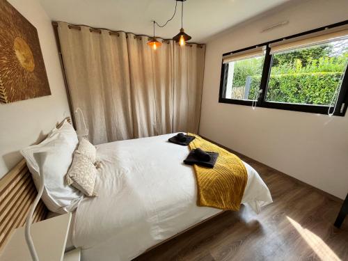 a bedroom with a large white bed with a window at DEGEMER MAT ! 4* Cosy, Moderne, à 8 min des plages. in Moëlan-sur-Mer