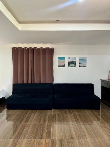 a living room with two couches in front of a window at Island Wanderers Inn in Coron