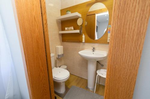 a bathroom with a toilet and a sink and a mirror at Domus Graciosa in Ponte de Lima