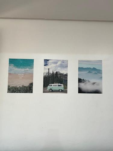 a group of four pictures on a white wall at Island Wanderers Inn in Coron