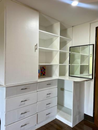 a white closet with white cabinets and a mirror at Island Wanderers Inn in Coron