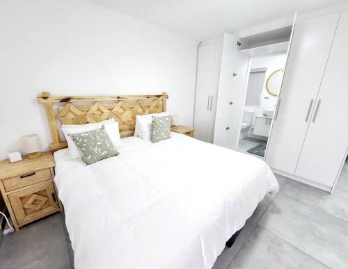 a white bedroom with a large white bed with pillows at Sunshine Sally in St Helena Bay