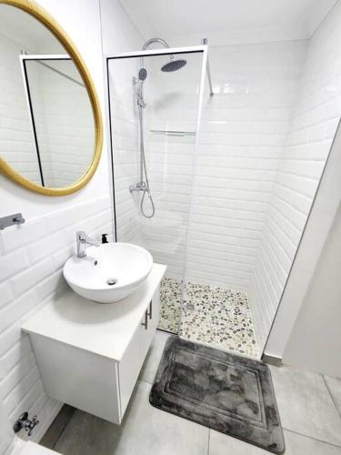a white bathroom with a sink and a shower at Sunshine Sally in St Helena Bay