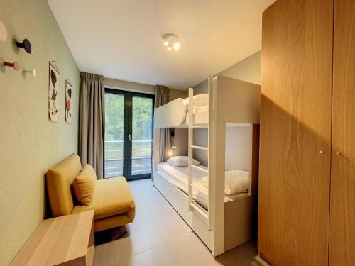 Cette petite chambre comprend des lits superposés et un canapé. dans l'établissement Appartement 'Thibault' te Oostduinkerke - Bad, à Oostduinkerke