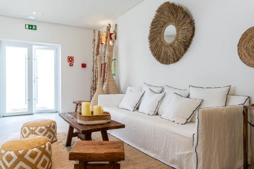 La Réserve Comporta في كارفالهال: غرفة معيشة مع أريكة بيضاء وطاولة