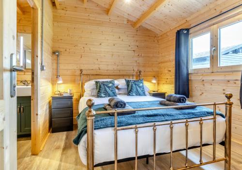 a bedroom with a bed in a log cabin at Foxglove Cabin in Devils Bridge