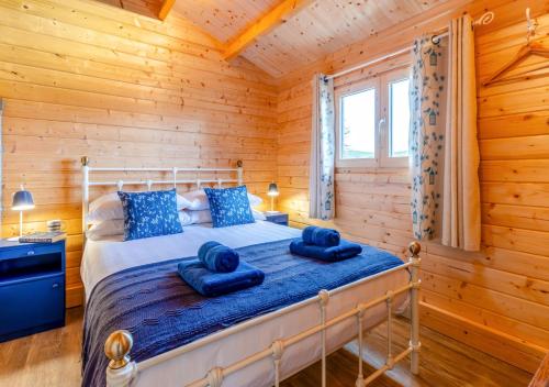 a bedroom with a bed in a log cabin at Bluebell Cabin in Devils Bridge