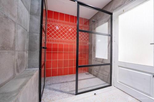 a glass door in a room with a red wall at Love Story Villas, Baga-Private Pool Villas in Arpora