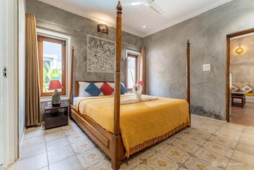 a bedroom with a bed with a yellow bedspread at Love Story Villas, Baga-Private Pool Villas in Arpora