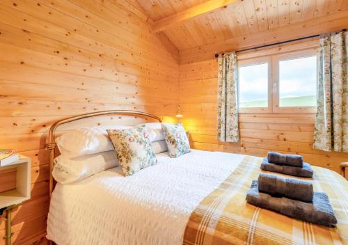 a bedroom with a bed in a log cabin at Rose Cabin in Devils Bridge