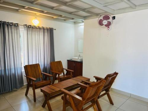 a dining room with chairs and a table and a tv at Brooke Forest Heaven Resort in Vythiri