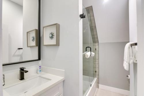 a white bathroom with a sink and a shower at Modern Houston Hideaway with Balcony 2 Mi to Dtwn! in Houston