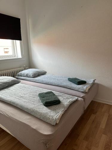 two beds in a room with towels on them at Grønne Esbjerg C in Esbjerg