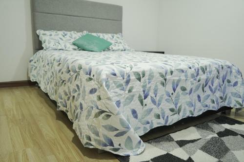 ein Bett mit einer blauen und weißen Bettdecke darauf in der Unterkunft CASA CAMPESTRE LA PRADERA in Cali