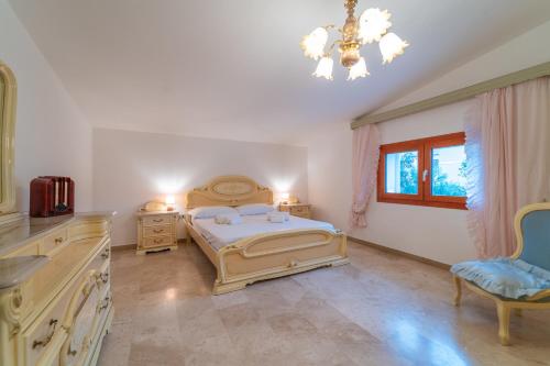 a bedroom with a bed and a chandelier at Brorent Domo de Aurora in Olbia