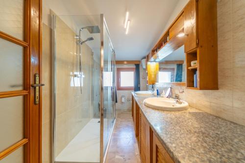 een badkamer met een glazen douche en een wastafel bij Brorent Domo de Aurora in Olbia