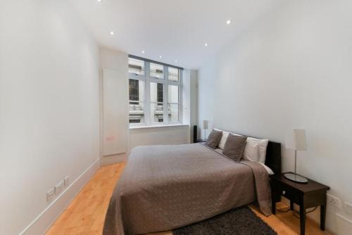 sypialnia z łóżkiem i oknem w obiekcie Best Mayfair Location with 2 Super King Beds w Londynie