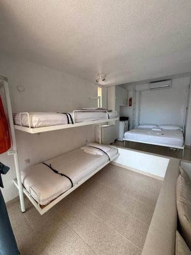a room with three bunk beds and a couch at ESTUDIO DOS PLAYAS LA MANGA in Murcia