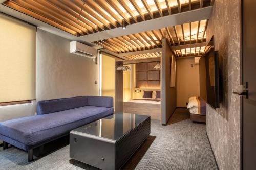a living room with a couch and a table at NEXUS HOTEL Gotanda in Tokyo