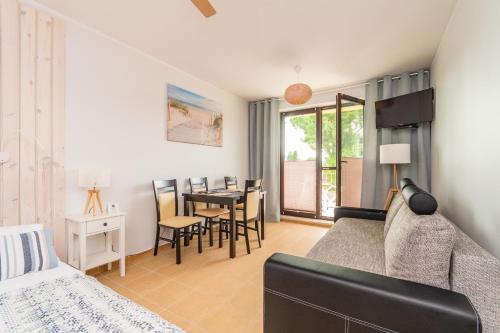 a living room with a bed and a table and chairs at Apartamenty NCNK przy Marinie w Kątach Rybackich in Kąty Rybackie