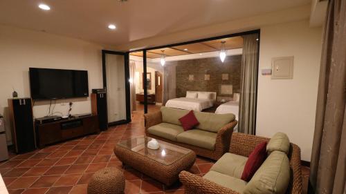 um quarto de hotel com uma cama e uma sala de estar em Bright Starry Hostel -Vacation in Donggang em Donggang