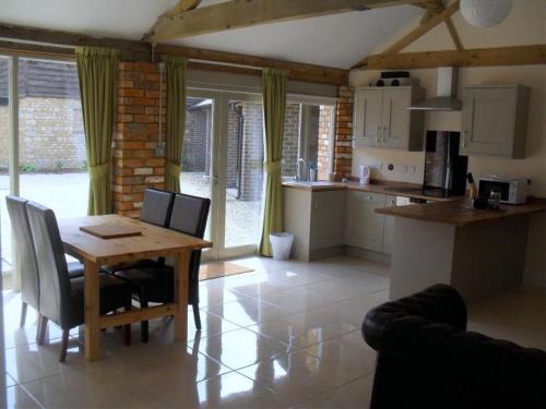 a kitchen and dining room with a table and chairs at Otters Holt at Tove Valley Cottages in Towcester