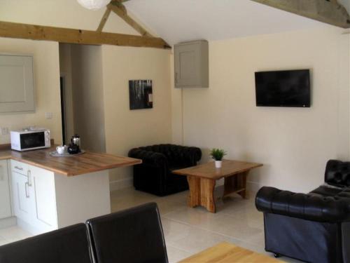 a kitchen and living room with a table and chairs at Otters Holt at Tove Valley Cottages in Towcester