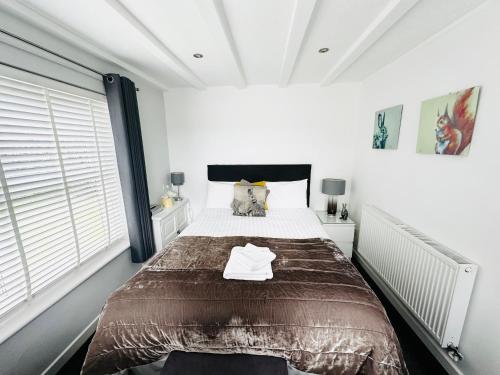 um quarto com uma cama grande num quarto branco em Cherry Bungalow Guesthouse em Shrivenham
