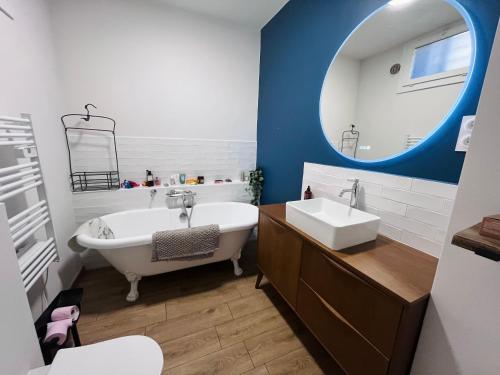 une salle de bain avec une baignoire, un lavabo et un miroir dans l'établissement Via Venaissia, à Pernes-les-Fontaines