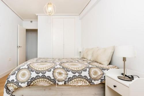 1 dormitorio con 1 cama y 1 mesa con lámpara en MyHouseSpain - Primera línea de playa con parking, en Gijón