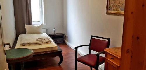 a room with a bed and a chair and a table at Apartments im Herzen Lübecks in Lübeck