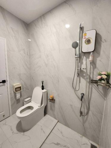 a white bathroom with a toilet and a shower at Baan Khongkwan Pool villa Khaoyai Pakchong in Pak Chong