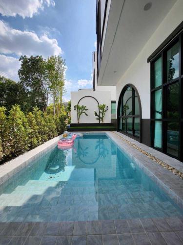 a swimming pool in the backyard of a house at Baan Khongkwan Pool villa Khaoyai Pakchong in Pak Chong