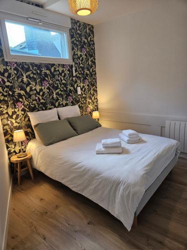 a bedroom with a bed with two towels on it at Le loft in Landerneau