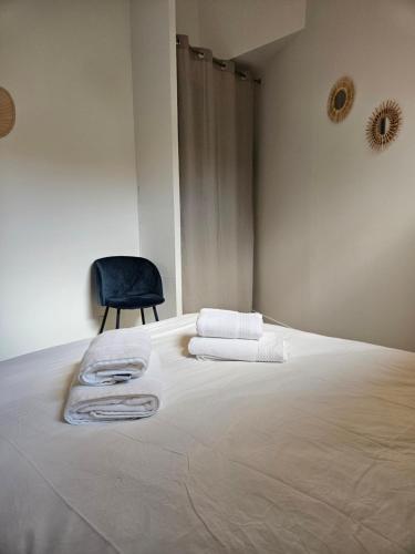 ein Schlafzimmer mit einem großen weißen Bett und einem Stuhl in der Unterkunft Le loft in Landerneau