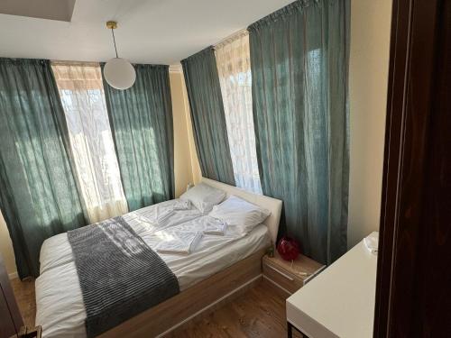 ein kleines Schlafzimmer mit einem Bett mit grünen Vorhängen in der Unterkunft Pensiunea Sun Victor in Baile Felix