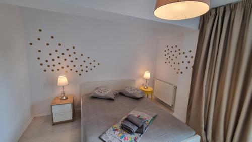 a bedroom with a bed with two pillows and two lamps at Airport Residence in Otopeni