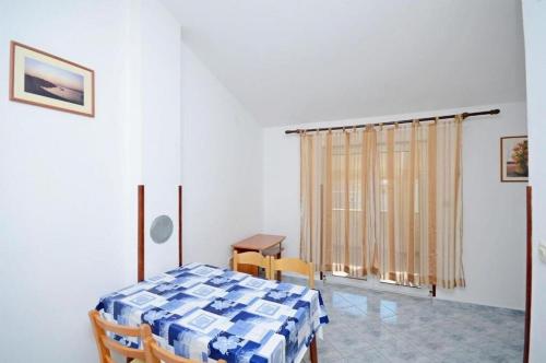 een kamer met een tafel en stoelen en een raam bij Apartments Ivan in Novalja